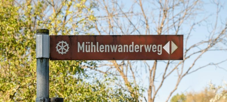 Das Hinweisschild zum Mühlenwanderweg an der Statue vom "Müllerborsch"