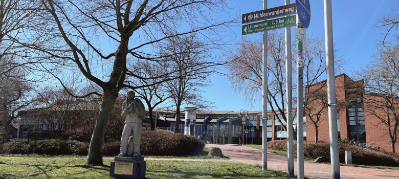 Das Hinweisschild zum Mühlenwanderweg an der Statue vom "Müllerborsch"