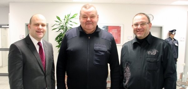 Das Bild zeigt drei Männer, die nebeneinander in einem hellen Raum stehen. Einer von ihnen ist Bürgermeister Daniel Tybussek. Alle blicken freundlich in die Kamera.