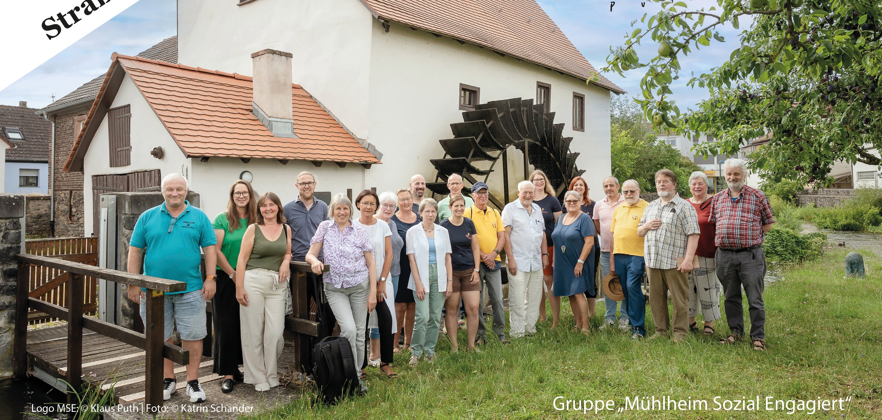 Das Plakat ist für die Woche des Ehrenamtes in Mühlheim. Oben steht groß: Woche des bürgerschaftlichen Engagements. Das bedeutet: Menschen helfen ehrenamtlich mit. In der Mitte ist ein Foto von einer Gruppe vor einer alten Mühle. Diese Gruppe heißt Mühlheim Sozial Engagiert. Links steht 19. September Straße des Ehrenamtes. Unten steht: 20. bis 30. September 2024, viele Veranstaltungen, Ehrenamt in Mühlheim kennenlernen.