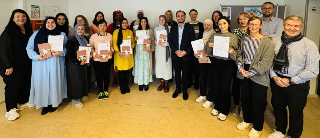 Eine große Gruppe von Frauen und Männern steht in einem Raum. Viele Frauen halten eine Urkunde in der Hand. Bürgermeister Dr. Alexander Krey steht in der Mitte. Alle lächeln in die Kamera.