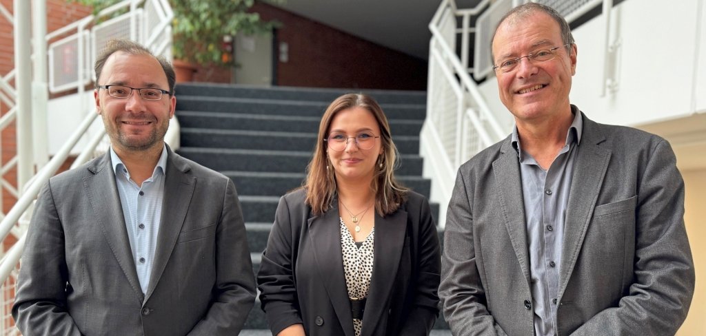 Drei Menschen stehen auf einer Treppe. In der Mitte steht Kristina Unrau. Sie ist die neue Klimamanagerin in Mühlheim. Links steht Bürgermeister Dr. Alexander Krey. Rechts steht Erster Stadtrat Robert Ahrnt. Alle lächeln in die Kamera.