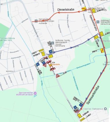 Das Bild zeigt eine Straßenkarte von Mühlheim am Main mit Fokus auf die Lämmerspieler Straße. Dort ist eine Kanalbaumaßnahme geplant. Rote, blaue und gelbe Linien markieren Umleitungen und Verkehrsführungen. Baustellenschilder, Umleitungspfeile und Sperrungen sind sichtbar. Die Umleitung erfolgt hauptsächlich über die Dieselstraße und die Spessartstraße.